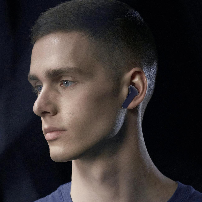 Į ausis įdedamos TWS Bluetooth belaidės ausinės, mėlynos